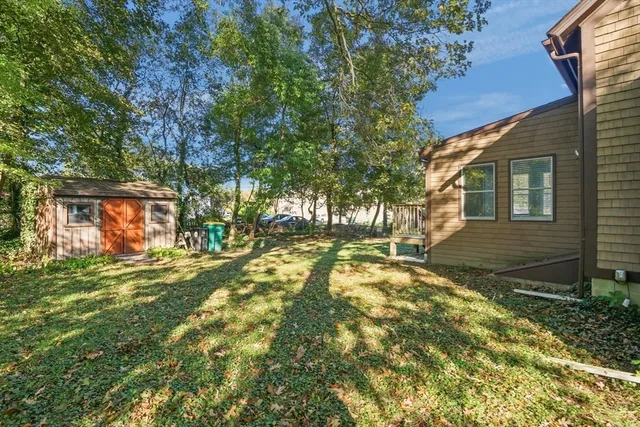 a view of a yard in front of a house with a large tree