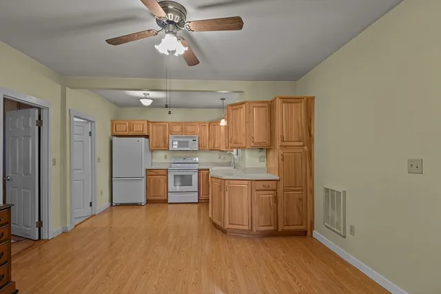a kitchen with cabinets and wooden floor