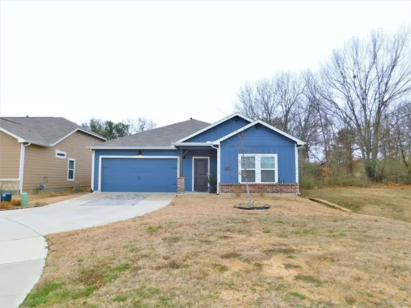 a big house with large trees and a wooden fence