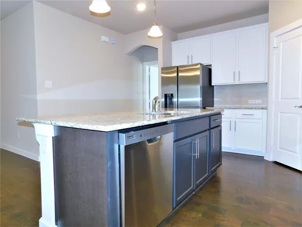 a kitchen with kitchen island granite countertop a stove sink and microwave