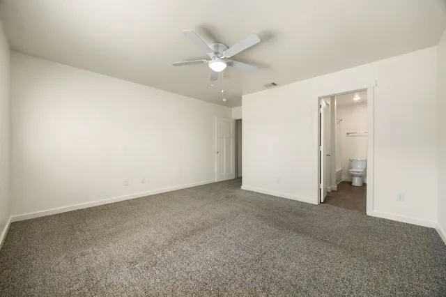 an empty room with closet and ceiling fan
