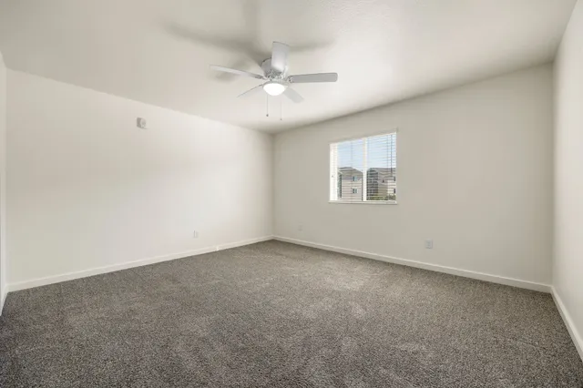 an empty room with a window and a fan