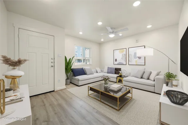 a living room with furniture and a wooden floor