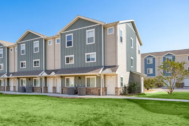an aerial view of residential houses with outdoor space and parking