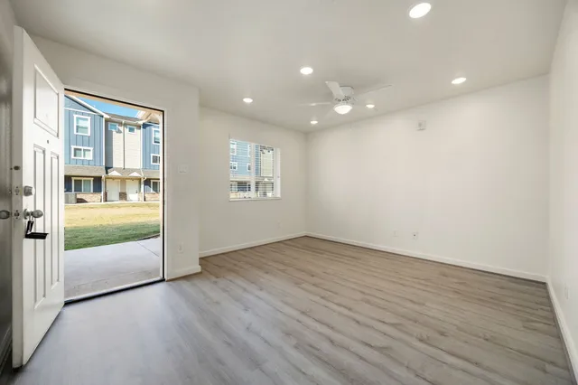 an empty room with wooden floor and windows