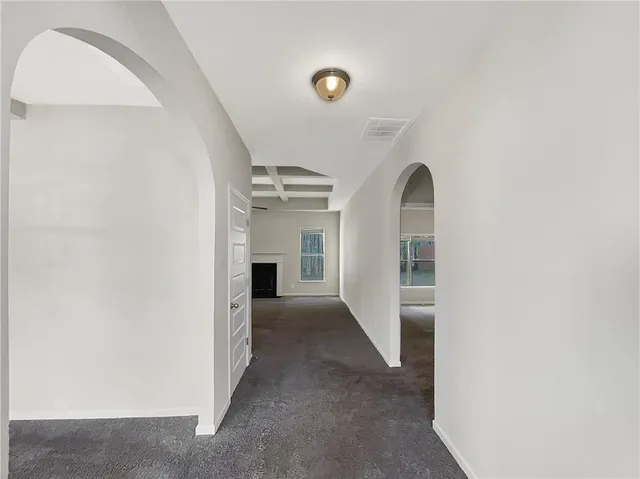 a view of an empty room with chandelier fan