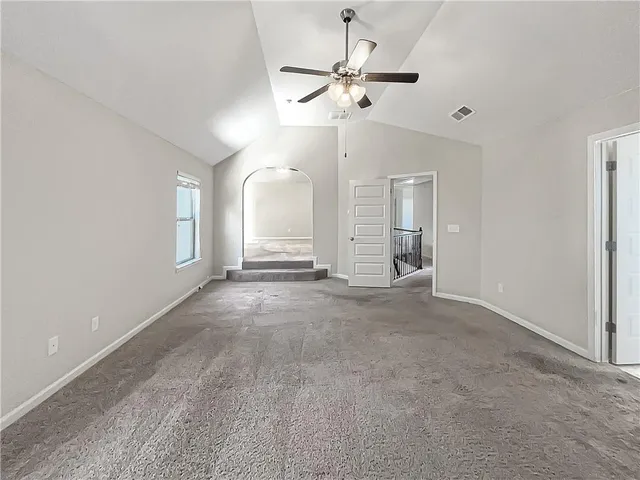 an empty room with fan and windows