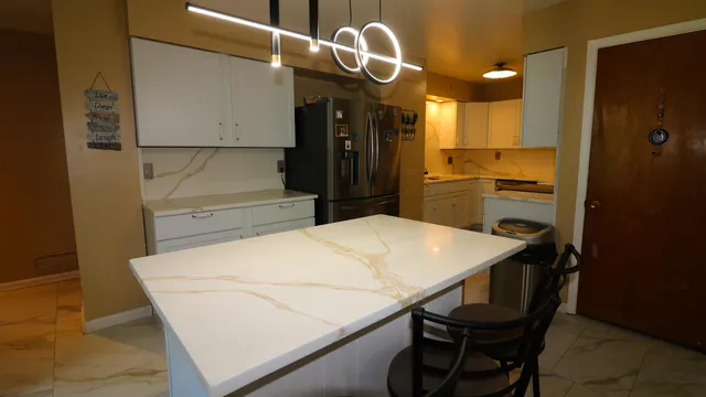 a kitchen with a table chairs refrigerator and cabinets