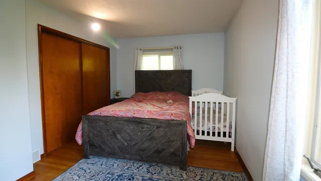a bedroom with a bed and wooden floor
