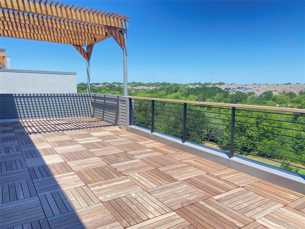 1111 Raiford Road, Unit 128 Carrollton, TX 75007 - Photo 4 of 18 Expansive rooftop terrace featuring wood-finish deck tiles, a slatted pergola, and a sleek cable railing with fabulous views. (construction photos - professional photos upon completion)