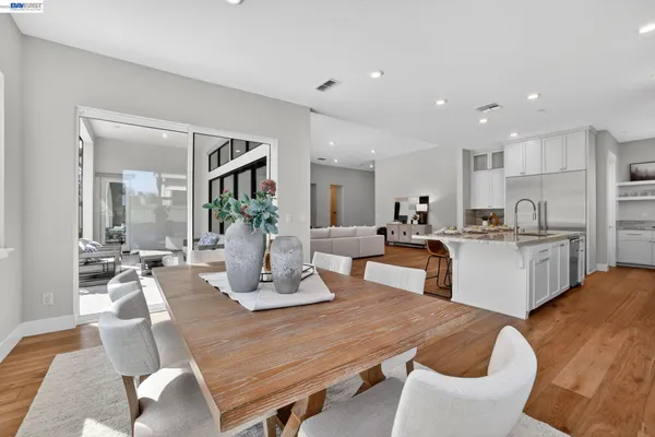 a view of a hallway with wooden floor and a bathroom