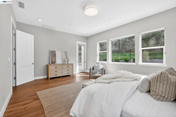 a spacious en suite bathroom with a granite countertop sink mirror and bathtub