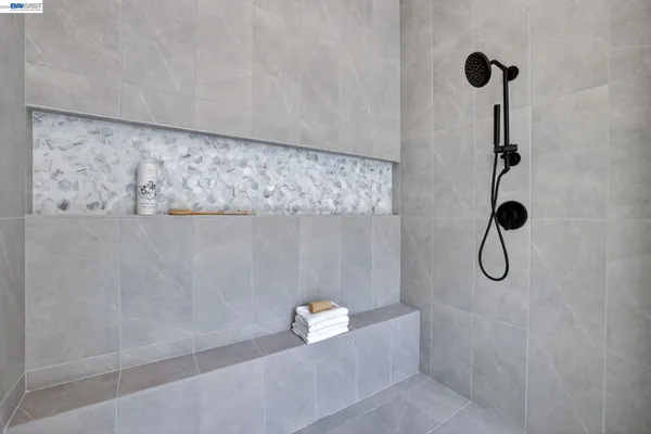 a large white bathroom with a double vanity sink a mirror and a shower