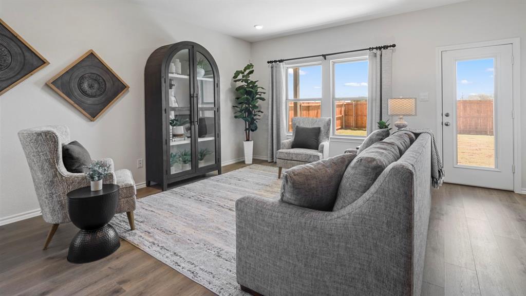 636 Dunham Road Nevada, TX 75173 - Photo 23 of 31 Spacious living area featuring wood-finish flooring, light grey walls, white trim, and multiple windows providing ample natural light