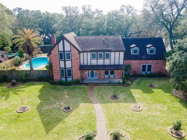 a view of a house with pool and a yard