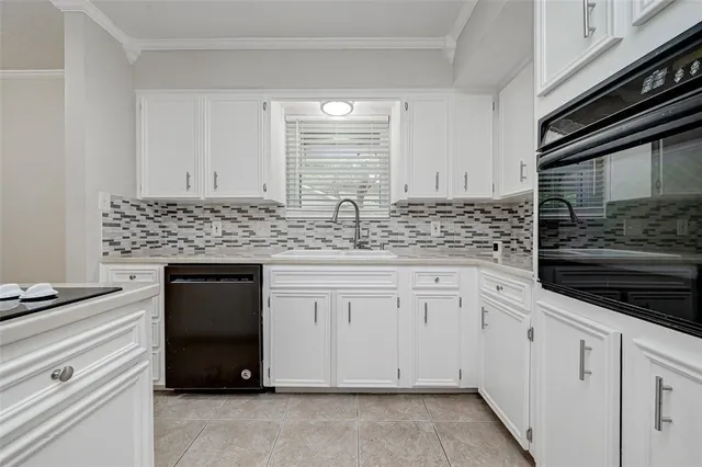 a kitchen with granite countertop white cabinets and stainless steel appliances