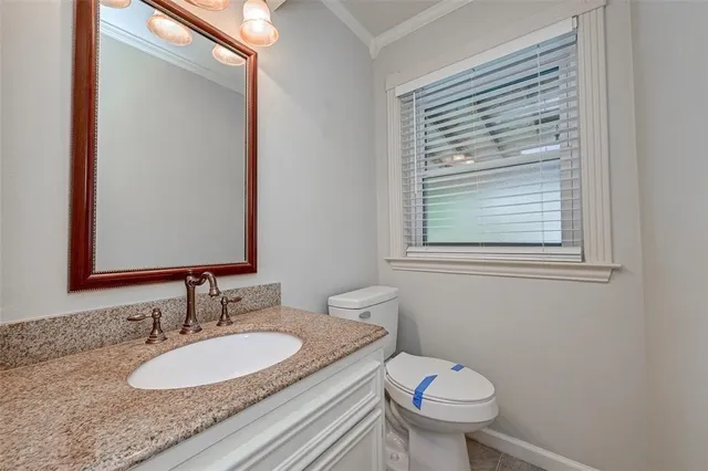a bathroom with a granite countertop toilet a sink and a mirror