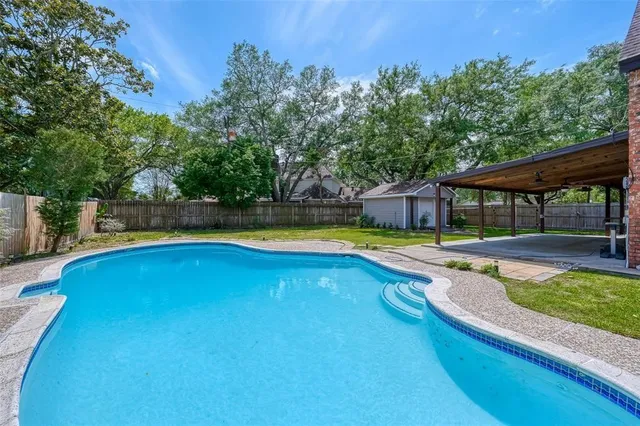 an outdoor space with swimming pool and furniture