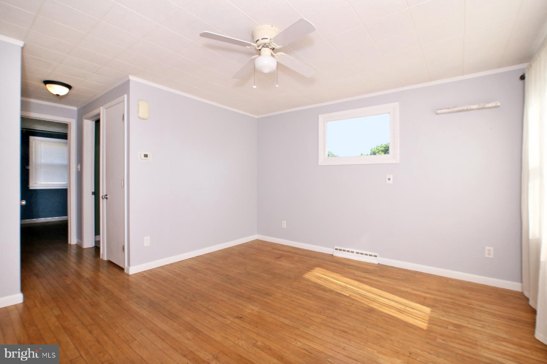 1217 Broadway Boulevard Reading, PA 19607 - Photo 8 of 35 an empty room with wooden floor and ceiling fan