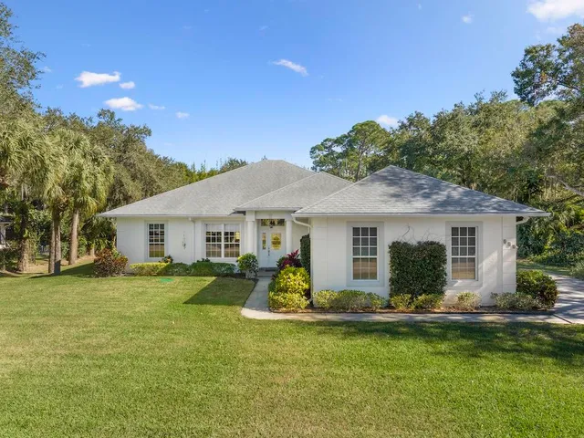 a view of a house with a yard patio and fire pit
