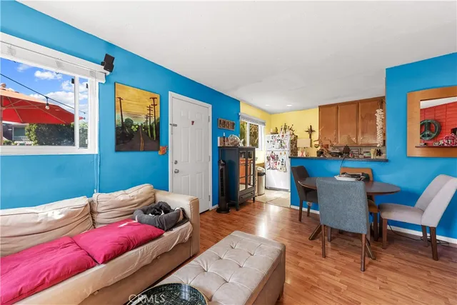 a living room with furniture and a dining table with wooden floor