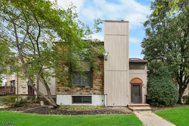 front view of house with a yard and large trees