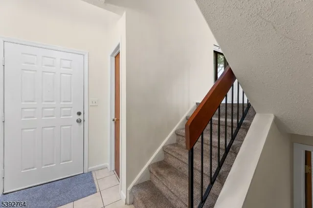 a view of staircase with railing and white walls