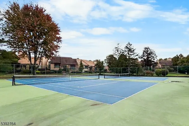 a view of a tennis ground with trees in the background