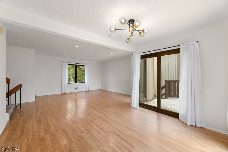65 Diamond Lane Old Bridge, NJ 08857 - Photo 8 of 33 a view of an empty room and window with wooden floor