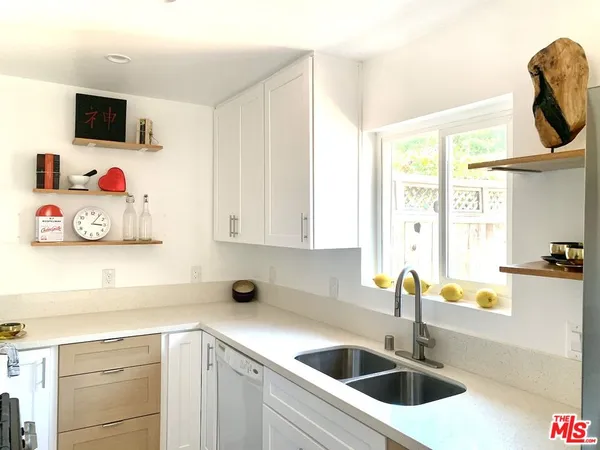 a kitchen with a sink and a stove top oven with wooden floor