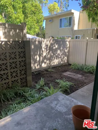 a view of backyard with outdoor seating and trees
