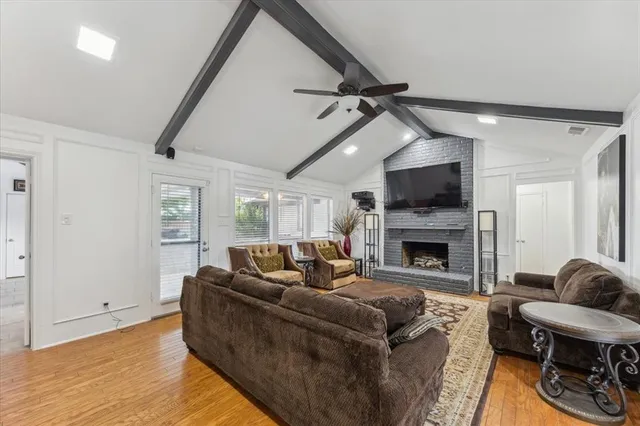 a living room with furniture a fireplace and a flat screen tv