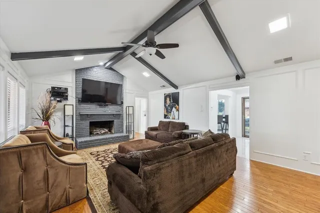 a living room with furniture a fireplace and a flat screen tv