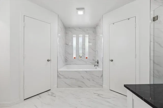 a spacious bathroom with a granite countertop sink and a mirror
