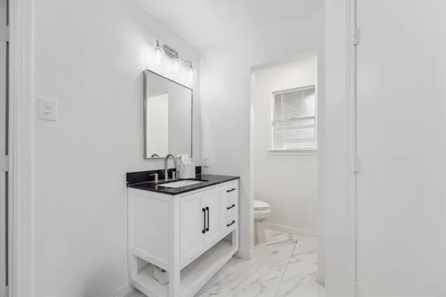a bathroom with a granite countertop sink and a mirror