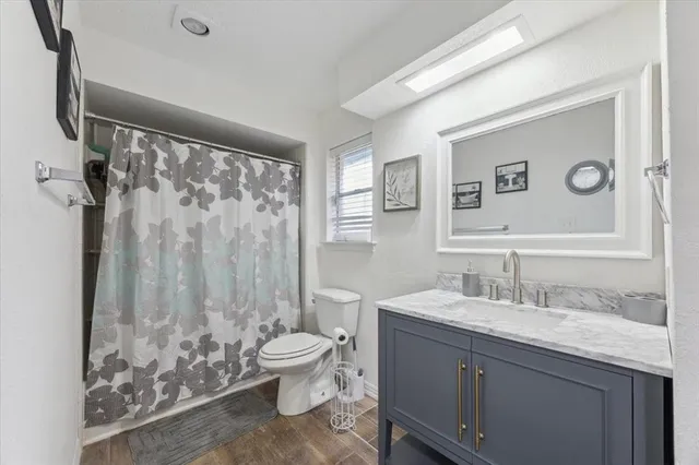 a bathroom with a granite countertop sink toilet and shower