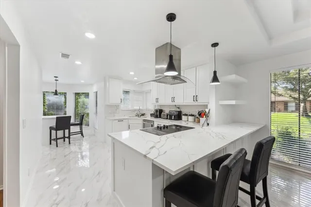 a kitchen with a table chairs sink and cabinets