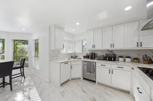 a kitchen with granite countertop white cabinets and white appliances