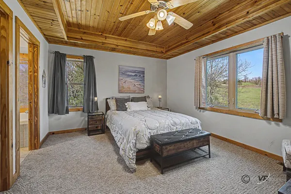 a spacious bedroom with a large bed and a chandelier
