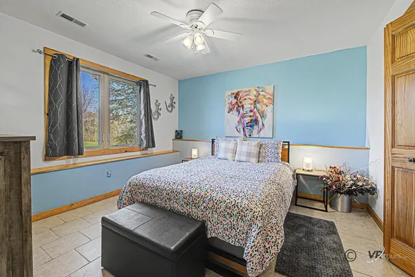 a bedroom with a bed and a painting on the wall