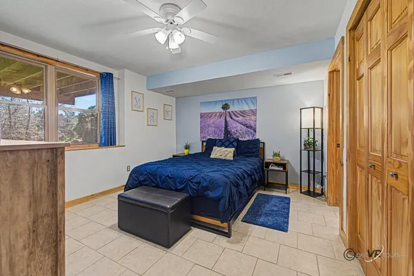 a spacious bedroom with a bed and glass window