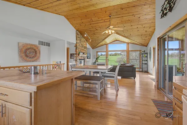 a dining hall with couches a flat tv screen and a dining table with garden view