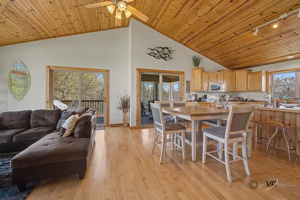a living room with furniture a wooden floor and kitchen view