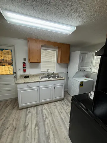 a kitchen with a sink wooden cabinets and black appliances