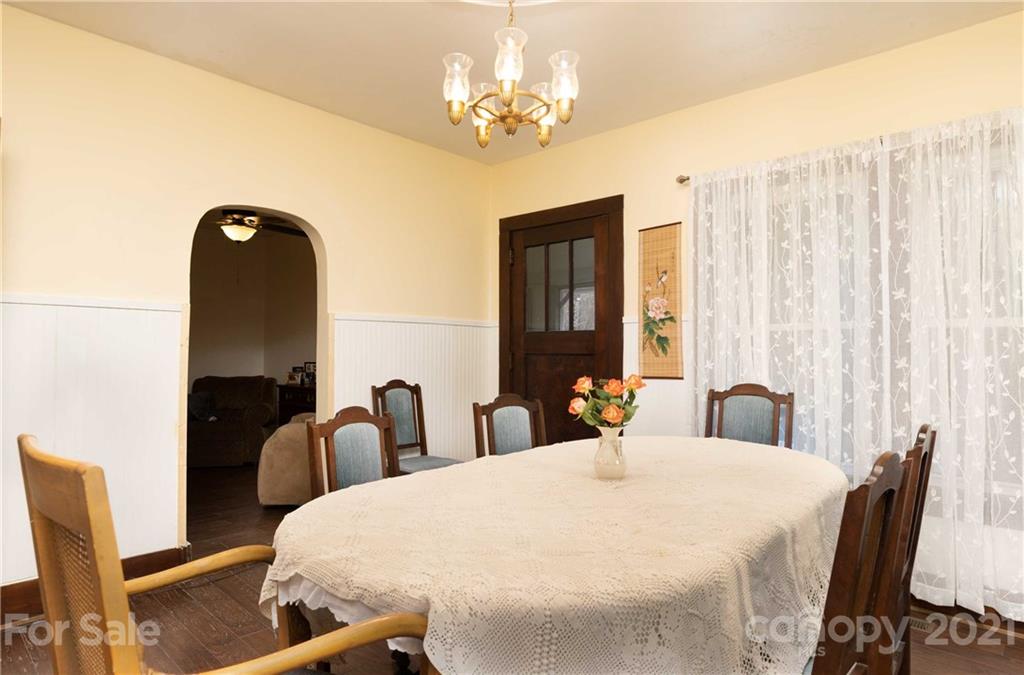 39 Baileys Peak Road Spruce Pine, NC 28777 - Photo 11 of 47 a bedroom with a large bed and a chandelier