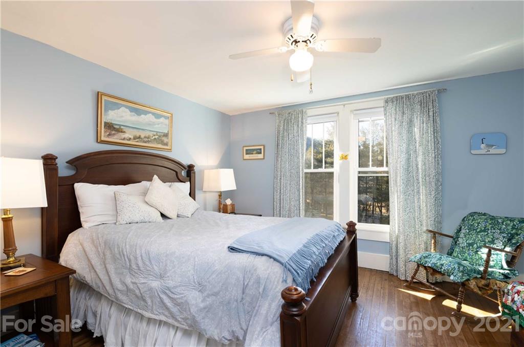 39 Baileys Peak Road Spruce Pine, NC 28777 - Photo 16 of 47 a bedroom with a large bed and a chandelier