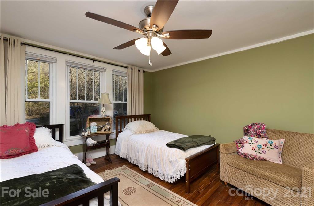 39 Baileys Peak Road Spruce Pine, NC 28777 - Photo 20 of 47 a bedroom with a bed and a chandelier
