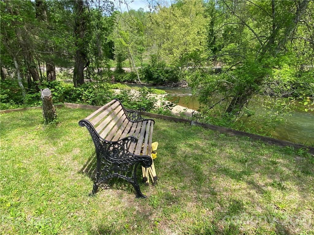 39 Baileys Peak Road Spruce Pine, NC 28777 - Photo 35 of 47 a wooden bench sitting in the middle of a garden