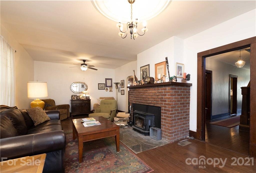 39 Baileys Peak Road Spruce Pine, NC 28777 - Photo 5 of 47 a living room with furniture a fireplace and a chandelier
