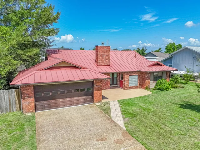 a front view of a house with yard and parking